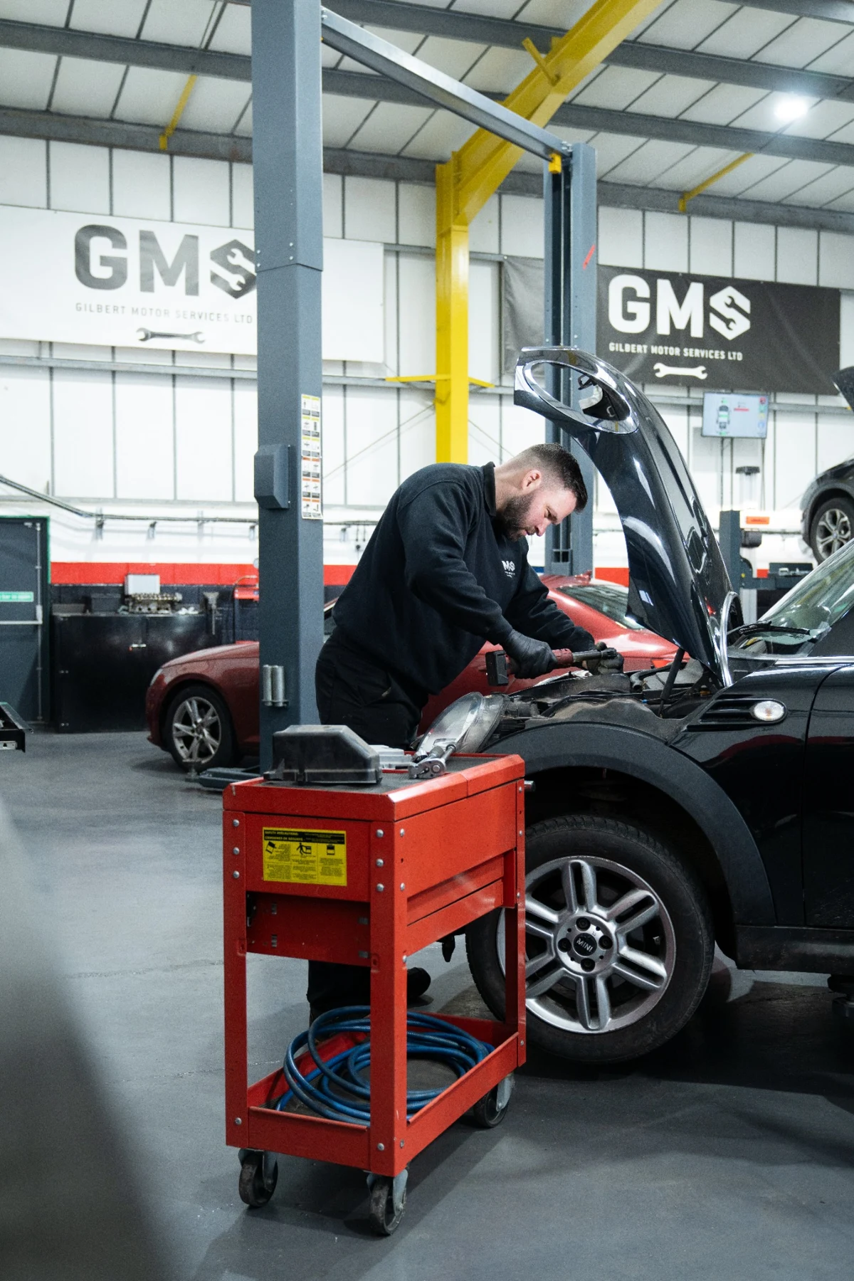GMS technician working under the bonnet of a MINI